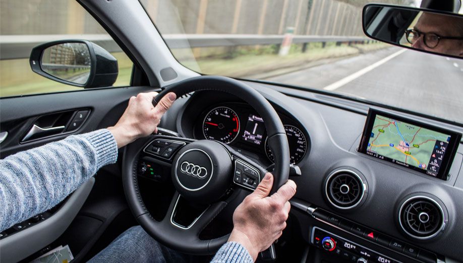 Man driving an Audi car showing dashboard Man driving an Audi car showing dashboard
