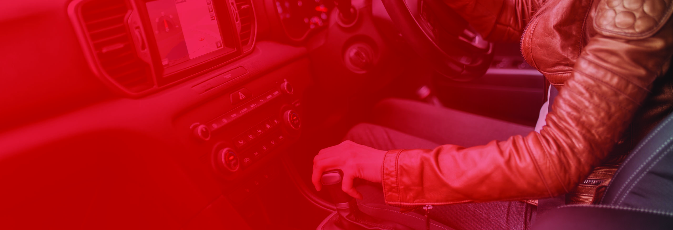 Young lady in leather jacket driving car with hand on gearstick. Automatic Driving Lessons in Worcester.